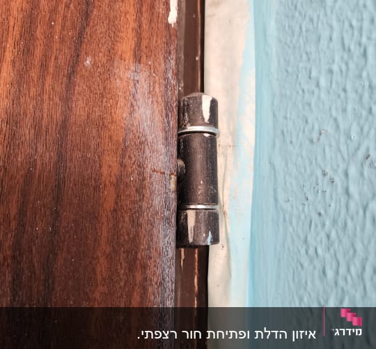 ציר דלת מתכת על קיר עץ
